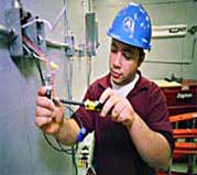 Color image showing an employee performing emergency repairs to electric box in a home
